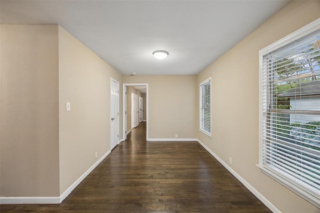 117 Moon Street Cleburne, TX 76033 - Photo 14 of 28 a view of an empty room with wooden floor and a window
