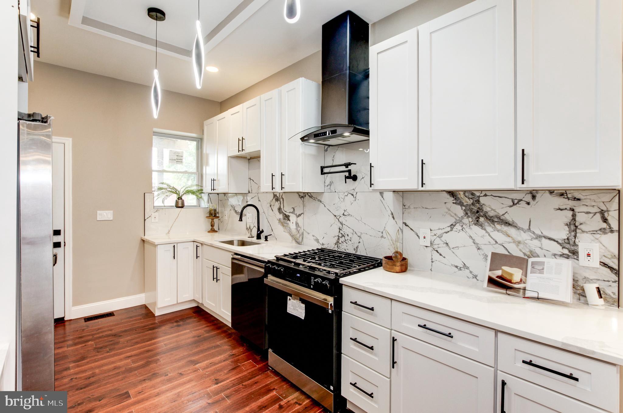 a kitchen with stainless steel appliances a stove a sink and a refrigerator
