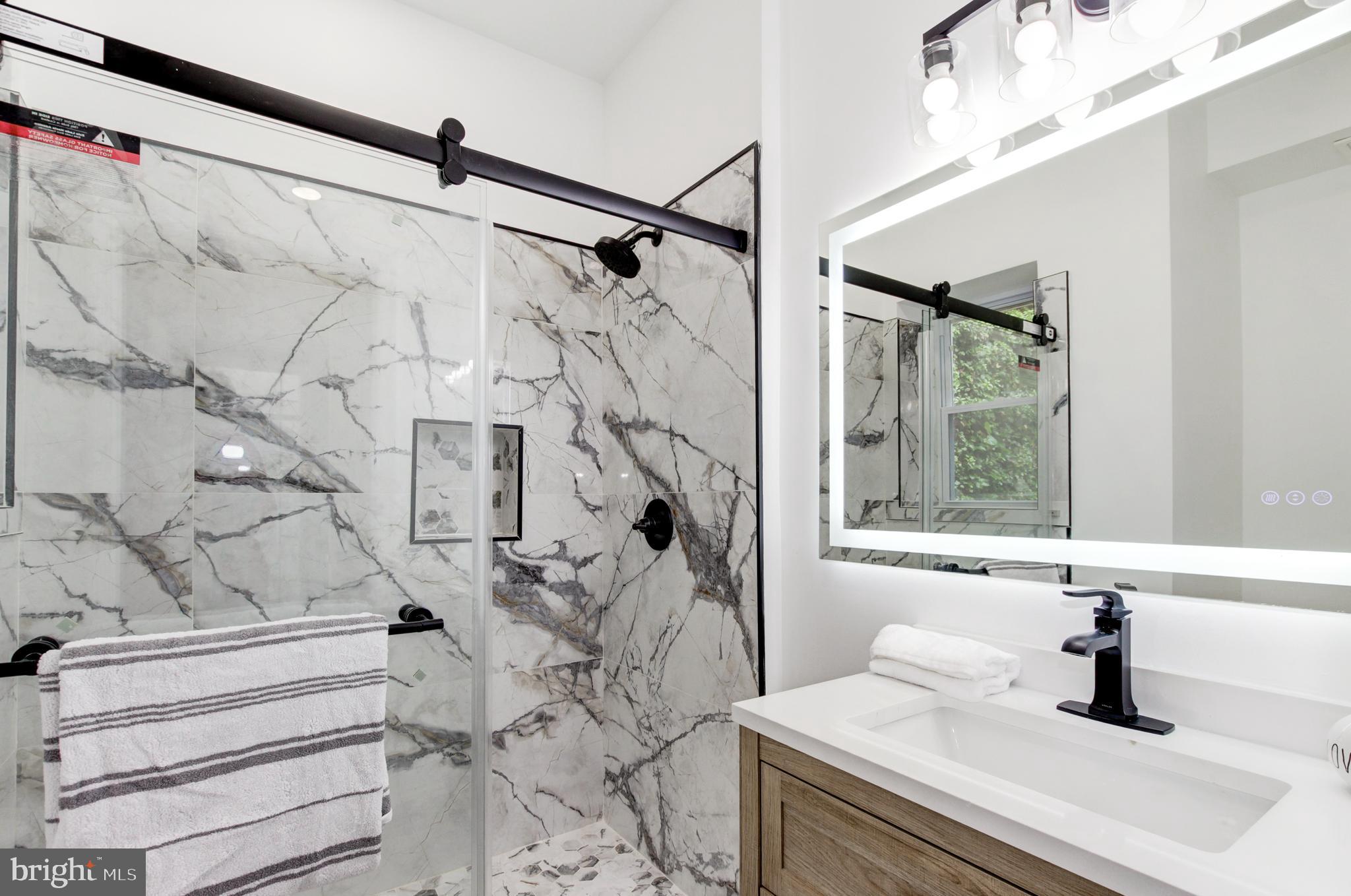 1324 Aisquith Street Baltimore, MD 21202 - Photo 18 of 47 a bathroom with a sink and mirror with bathtub