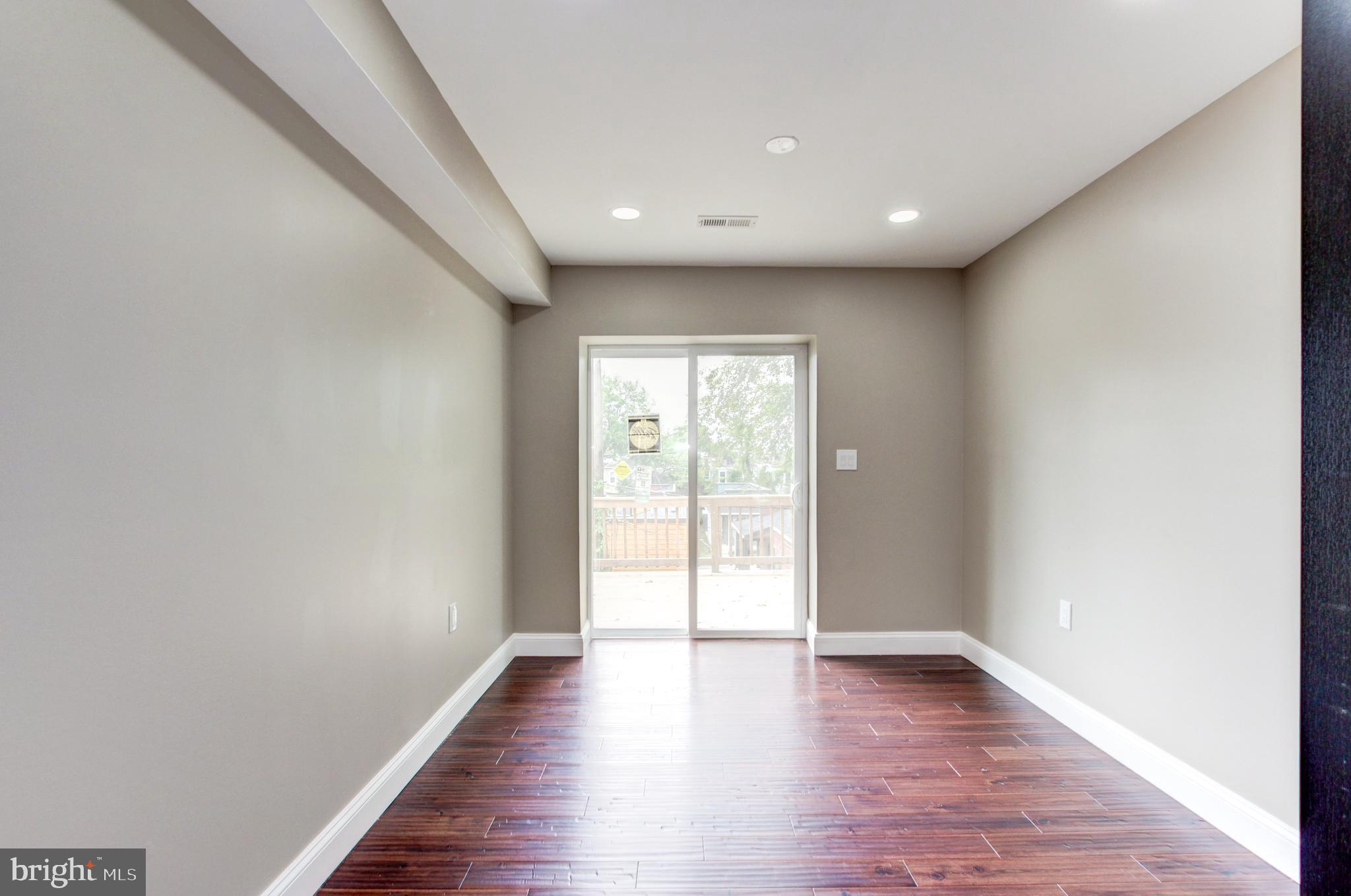1324 Aisquith Street Baltimore, MD 21202 - Photo 19 of 47 a view of an empty room with wooden floor and a window