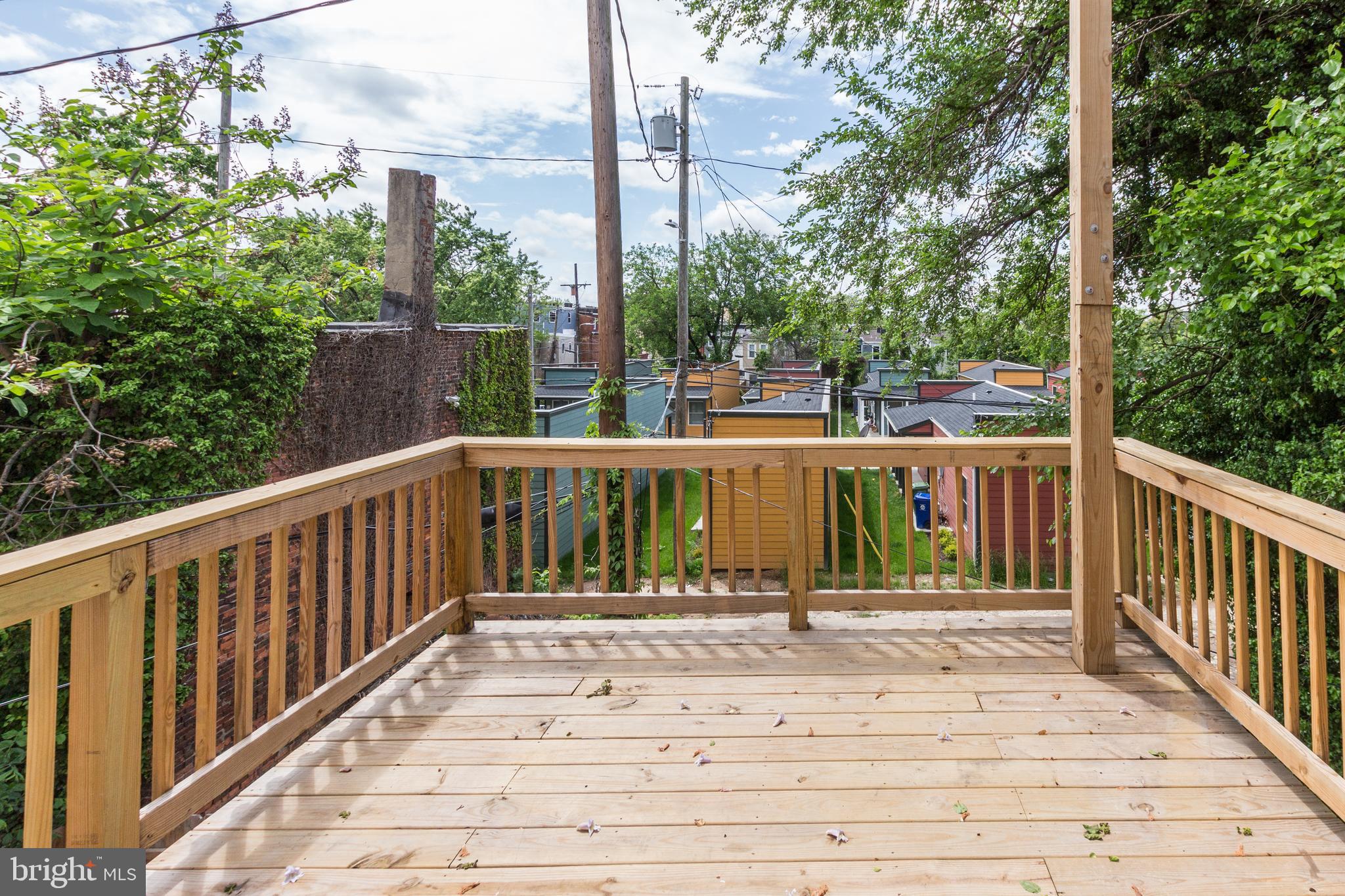 1324 Aisquith Street Baltimore, MD 21202 - Photo 23 of 47 a view of a balcony with wooden floor next to a yard