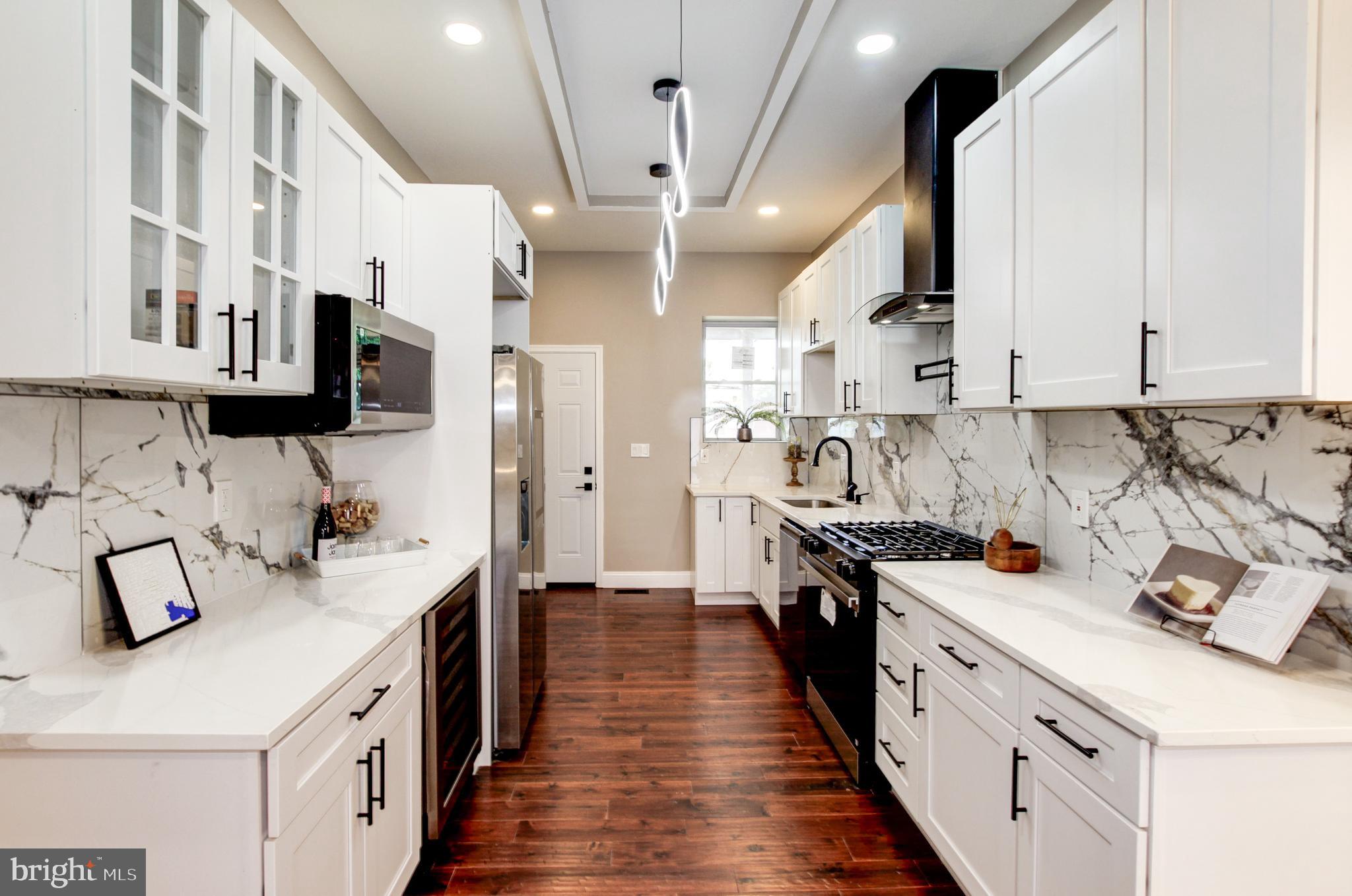1324 Aisquith Street Baltimore, MD 21202 - Photo 3 of 47 a kitchen with stainless steel appliances a sink stove and cabinets