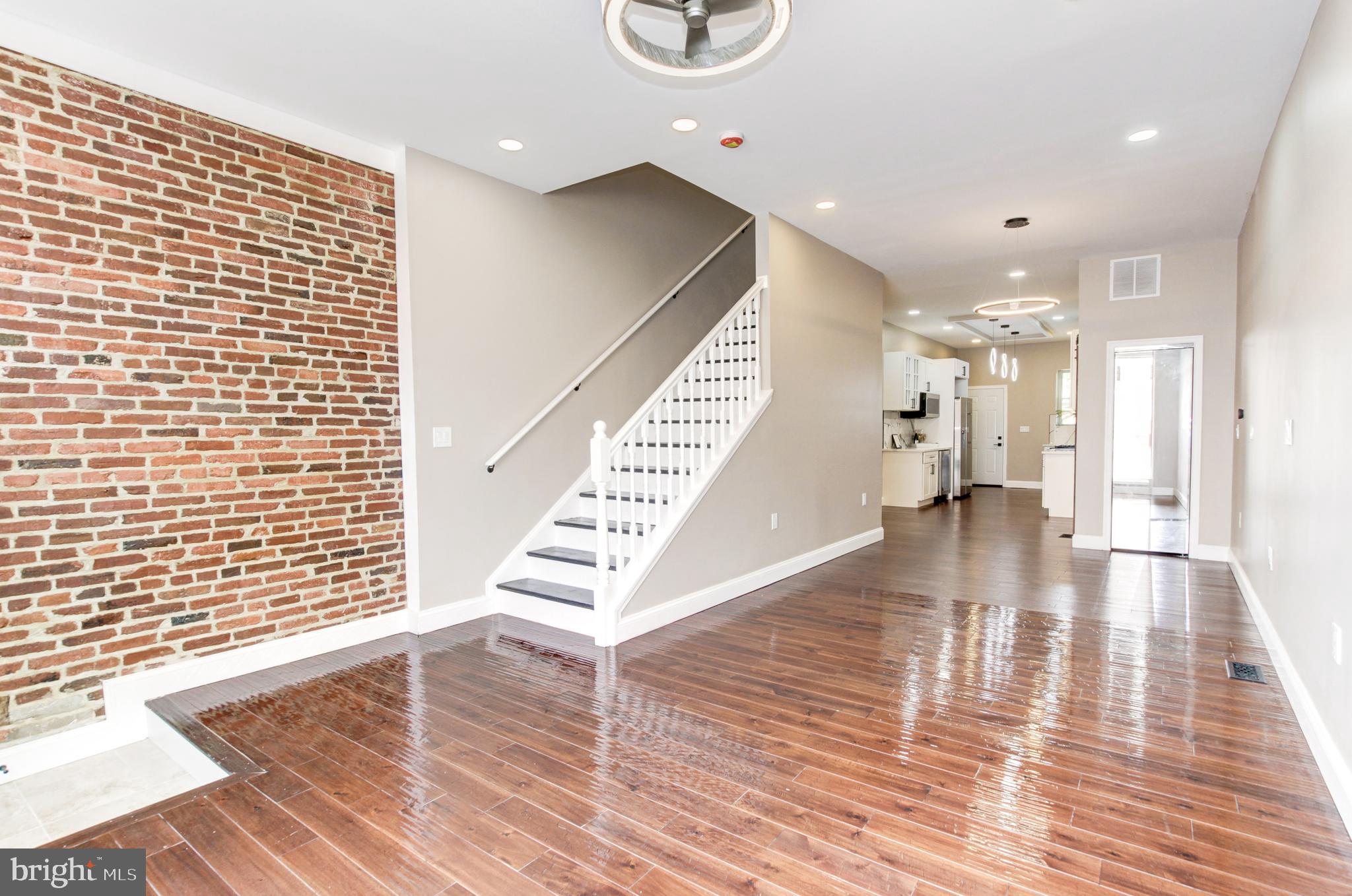 1324 Aisquith Street Baltimore, MD 21202 - Photo 7 of 47 a view of an empty room with wooden floor and a potted plant