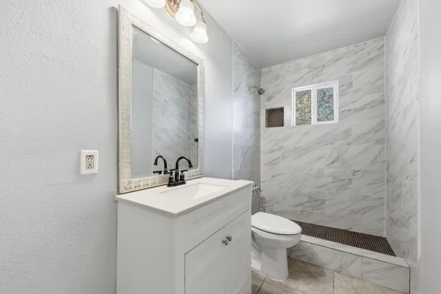 a bathroom with a sink a toilet and mirror