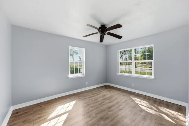 a view of a big room with wooden floor and windows in a room