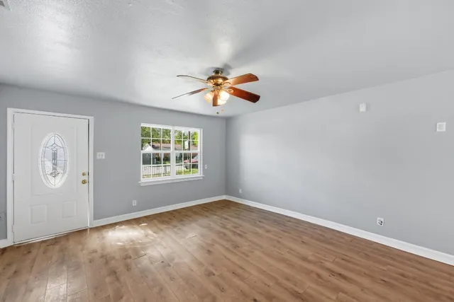 wooden floor in an empty room with a window