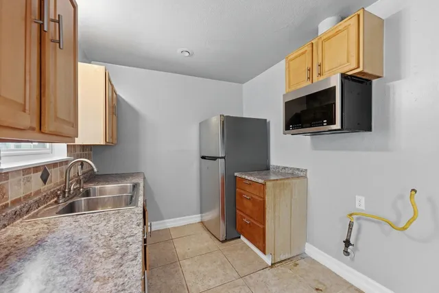 a kitchen with stainless steel appliances a sink a stove a microwave a counter top space and cabinets