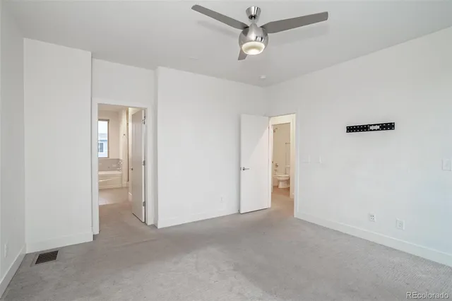 a view of an empty room and a ceiling fan