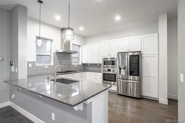 a kitchen with stainless steel appliances granite countertop a sink refrigerator and microwave