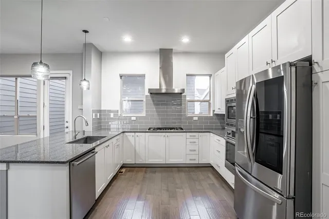 a kitchen with stainless steel appliances granite countertop a sink refrigerator and cabinets