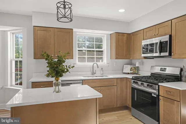 a kitchen with stainless steel appliances granite countertop a sink stove and microwave