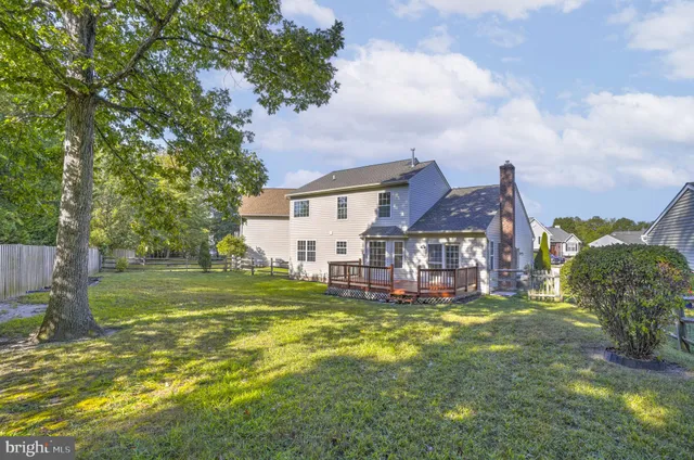 a view of a house with a big yard and large trees