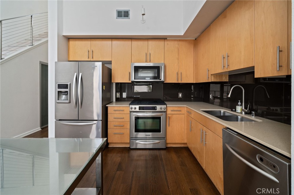133 The, Unit 404 Long Beach, CA 90802 - Photo 7 of 25 a kitchen with a sink a microwave a refrigerator and cabinets