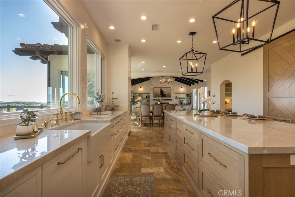 4567 Sleeping Indian Road Fallbrook, CA 92028 - Photo 23 of 72 a large kitchen with stainless steel appliances a large counter top a stove and a sink