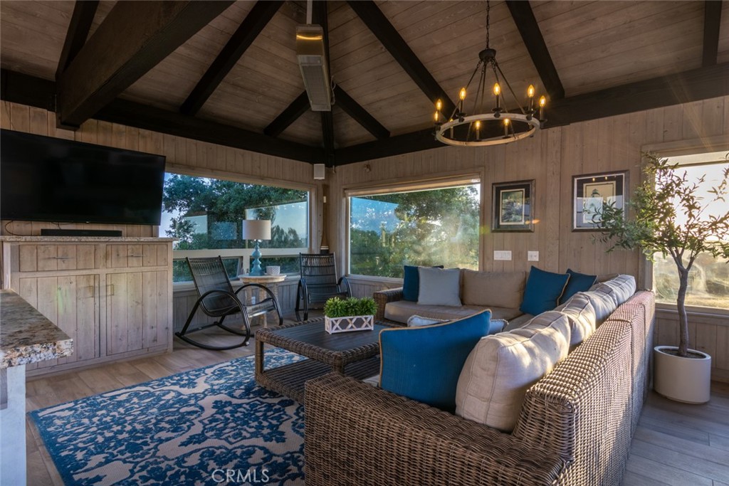 4567 Sleeping Indian Road Fallbrook, CA 92028 - Photo 32 of 72 a living room with furniture a flat screen tv and a floor to ceiling window