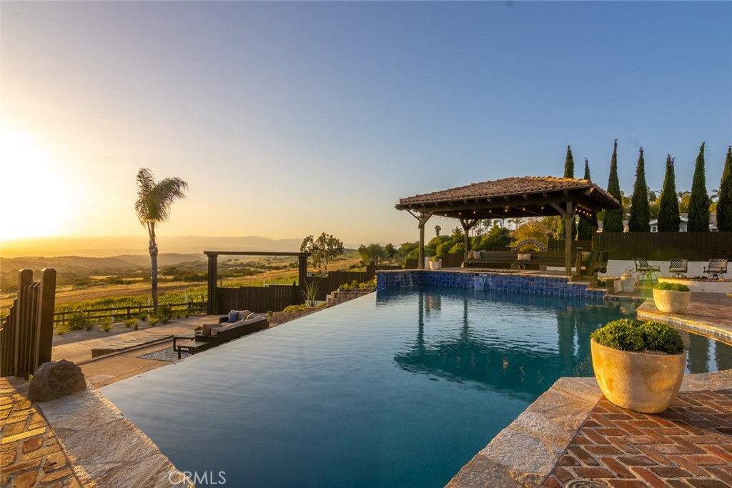 4567 Sleeping Indian Road Fallbrook, CA 92028 - Photo 6 of 72 a view of a swimming pool with a lounge chairs