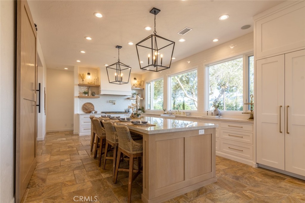 4567 Sleeping Indian Road Fallbrook, CA 92028 - Photo 8 of 72 a kitchen with kitchen island granite countertop a stove a sink a dining table and chairs