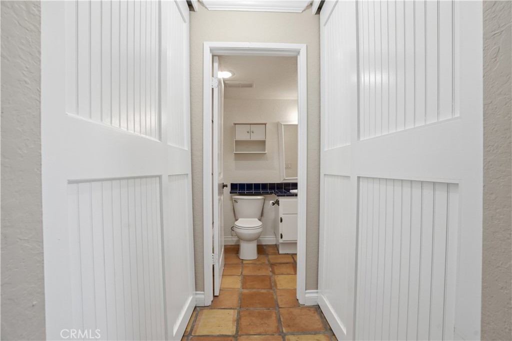 20702 El Toro Road, Unit 231 Lake Forest, CA 92630 - Photo 15 of 36 a view of a hallway with toilet and a bathroom with mirror