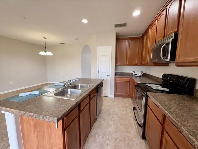 a kitchen with stainless steel appliances granite countertop a stove refrigerator and microwave