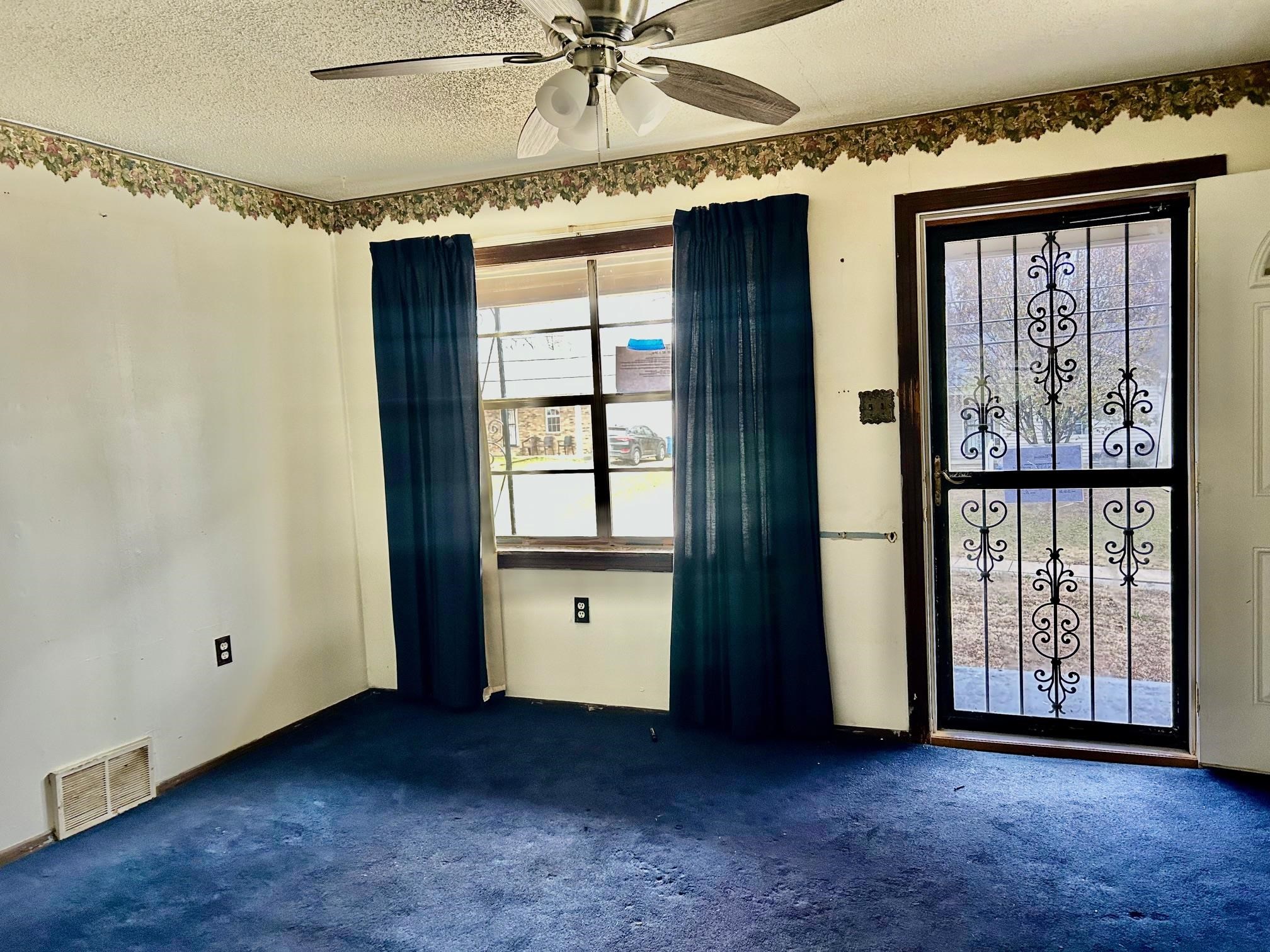 409 Hill Avenue Covington, TN 38019 - Photo 4 of 11 an empty room with windows and fan