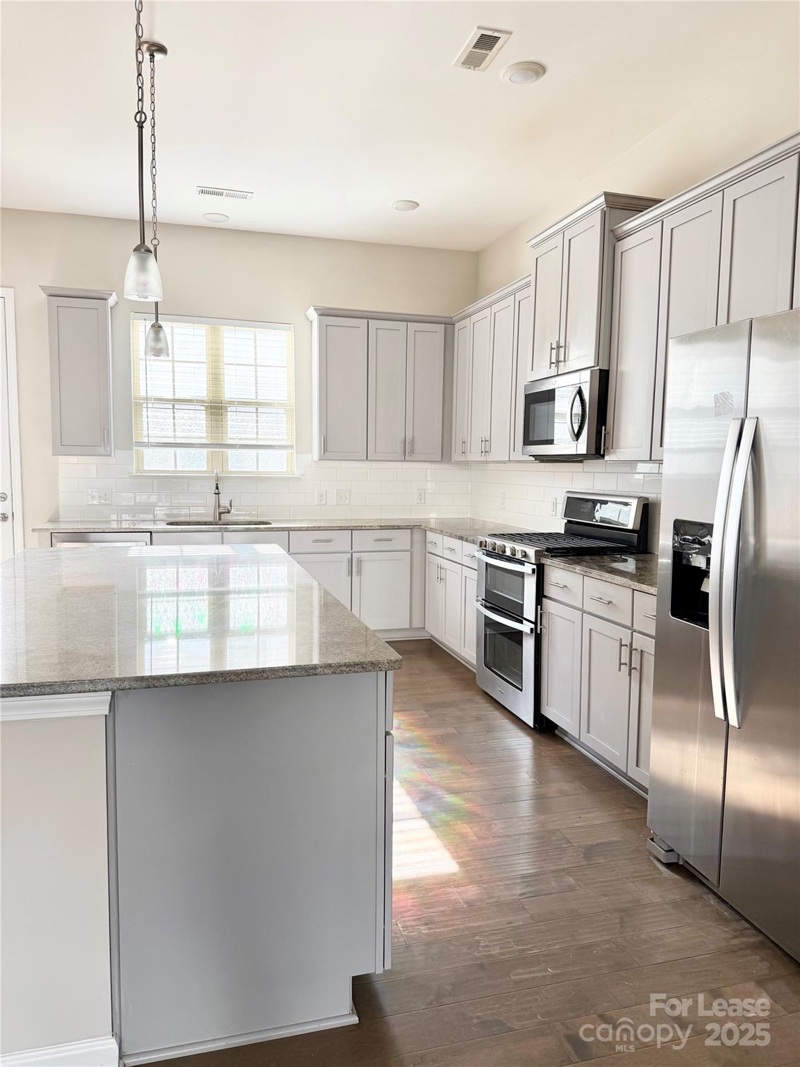 1138 Doveridge Street Charlotte, NC 28273 - Photo 9 of 22 a kitchen with stainless steel appliances granite countertop a stove a sink and white cabinets