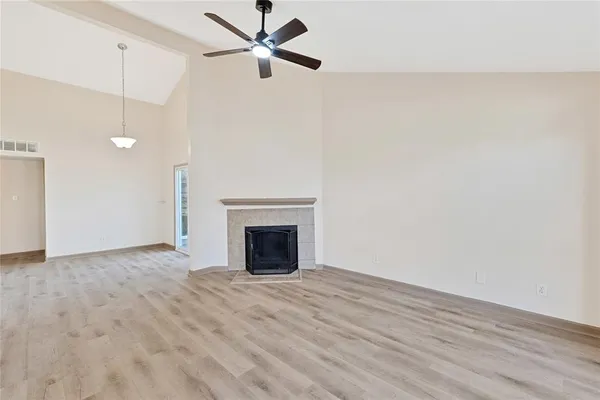 an empty room with fan and windows