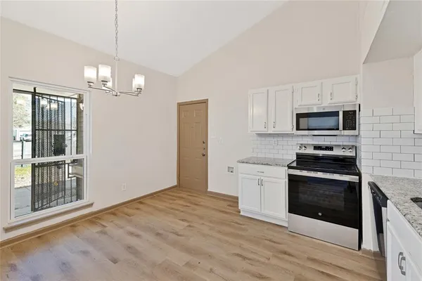 a kitchen with granite countertop a stove top oven and cabinets