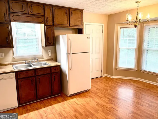 a kitchen with a refrigerator sink and cabinets