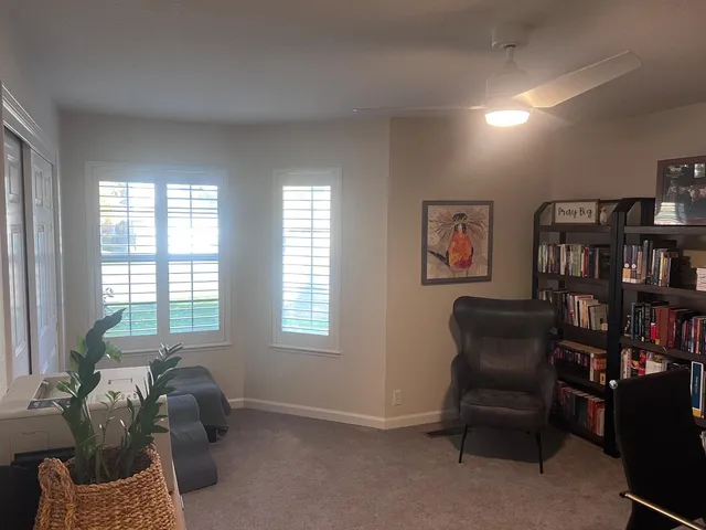 a livingroom with window and lounge chair
