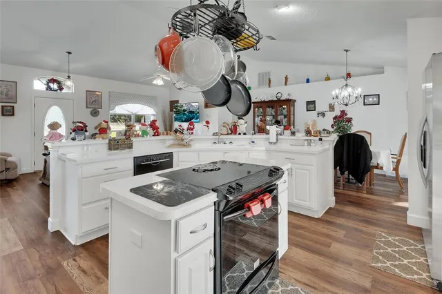 a kitchen that has a lot of white cabinets and stainless steel appliances