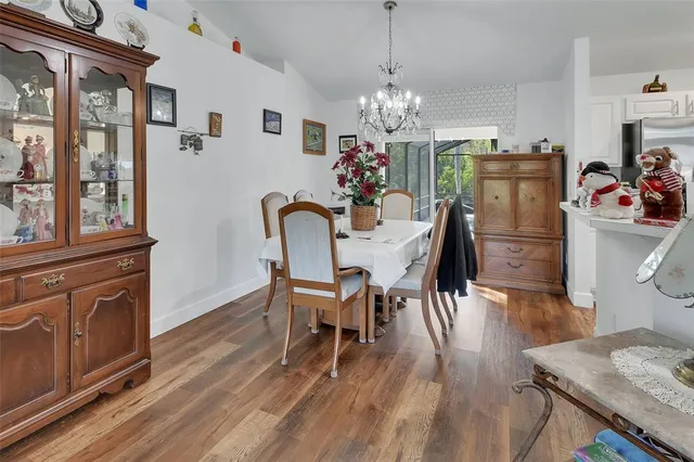a view of a dining room with furniture a chandelier and wooden floor
