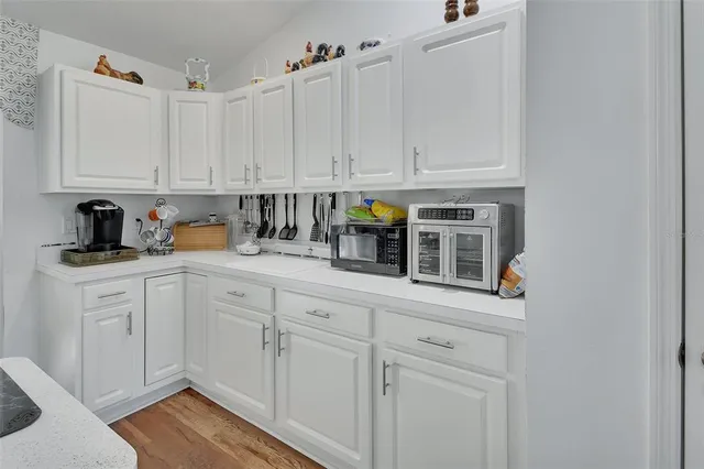 a kitchen with white cabinets and white appliances
