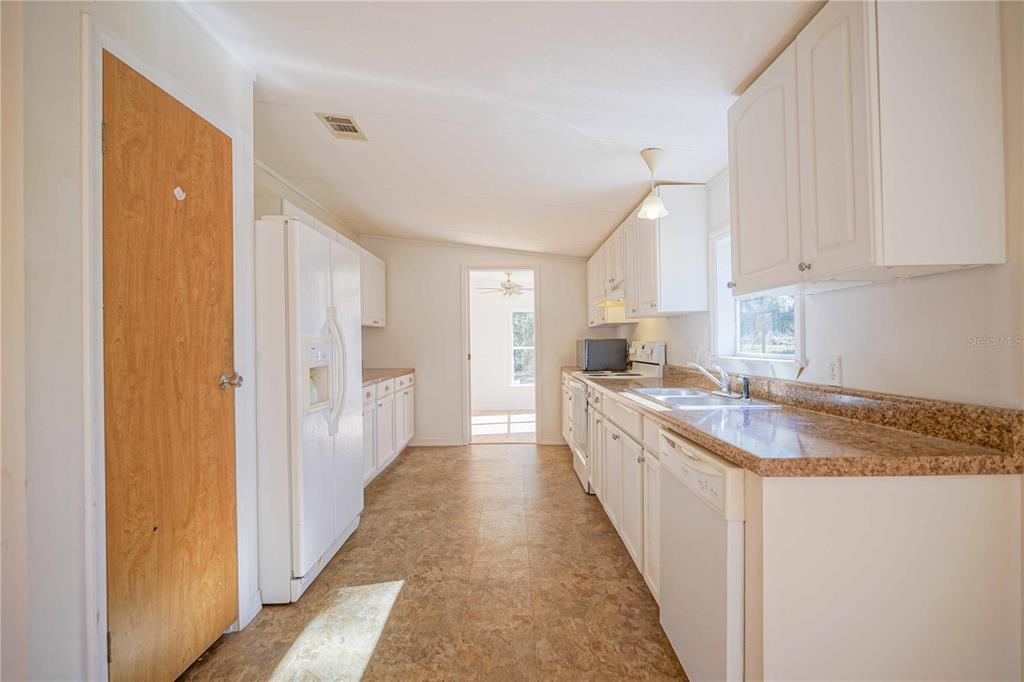 16621 Southwest 45th Street Ocala, FL 34481 - Photo 16 of 52 a kitchen with granite countertop sink stove and white cabinets