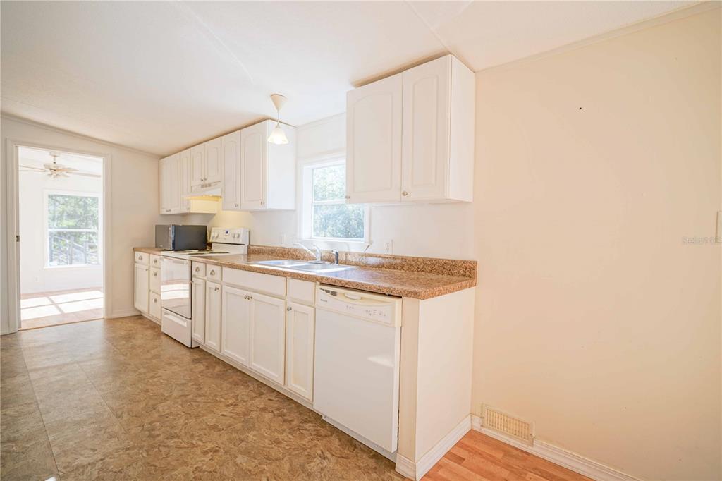 16621 Southwest 45th Street Ocala, FL 34481 - Photo 18 of 52 a kitchen with granite countertop white cabinets and white appliances