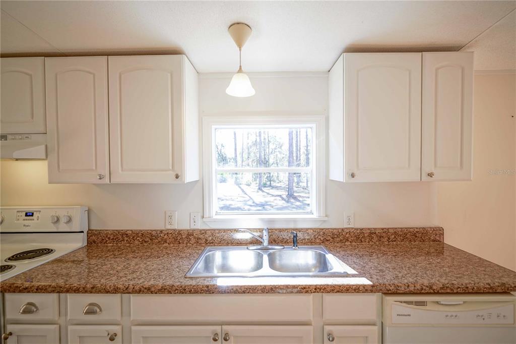 16621 Southwest 45th Street Ocala, FL 34481 - Photo 19 of 52 a kitchen with granite countertop white cabinets and a window