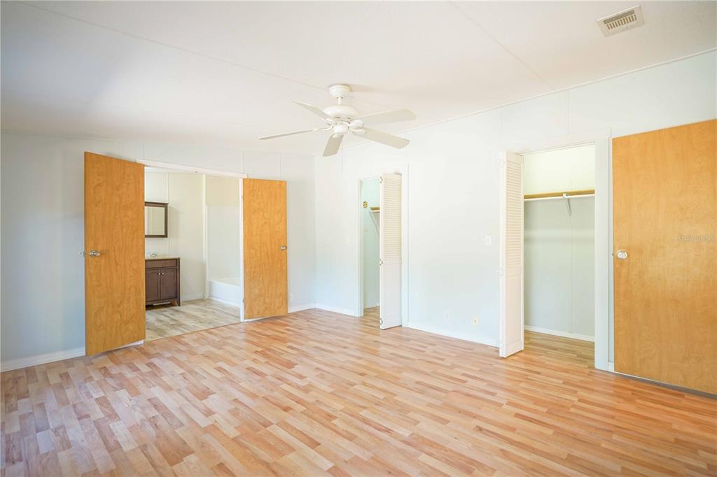 16621 Southwest 45th Street Ocala, FL 34481 - Photo 26 of 52 a view of a big room with wooden floor and a ceiling fan