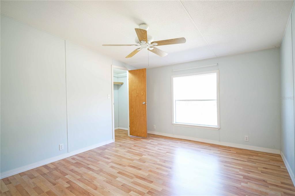 16621 Southwest 45th Street Ocala, FL 34481 - Photo 32 of 52 an empty room with wooden floor ceiling fan and windows