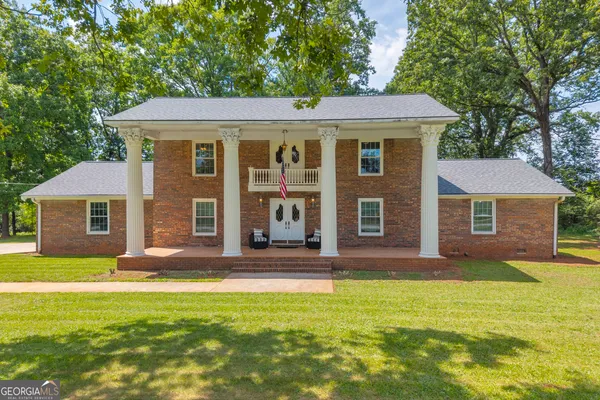 a view of a hallway to room with wooden floor