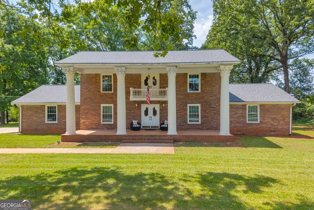 a view of a hallway to room with wooden floor