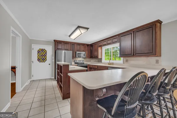 a kitchen with stainless steel appliances wooden cabinets a stove and a sink