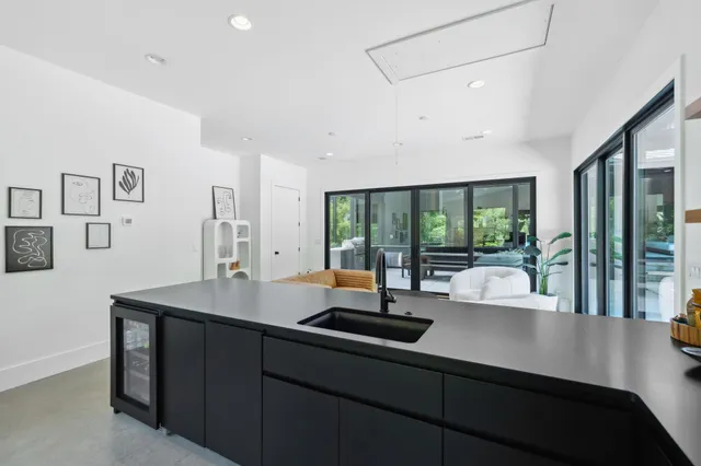 a view of a patio with table and chairs potted plants with floor to ceiling window and potted plants