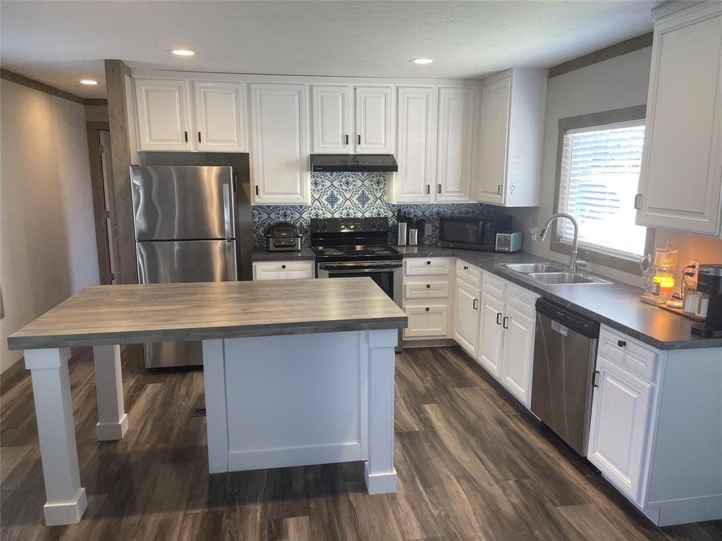 4937 Stuart Road Denton, TX 76207 - Photo 13 of 19 a kitchen with stainless steel appliances granite countertop a sink stove refrigerator and cabinets