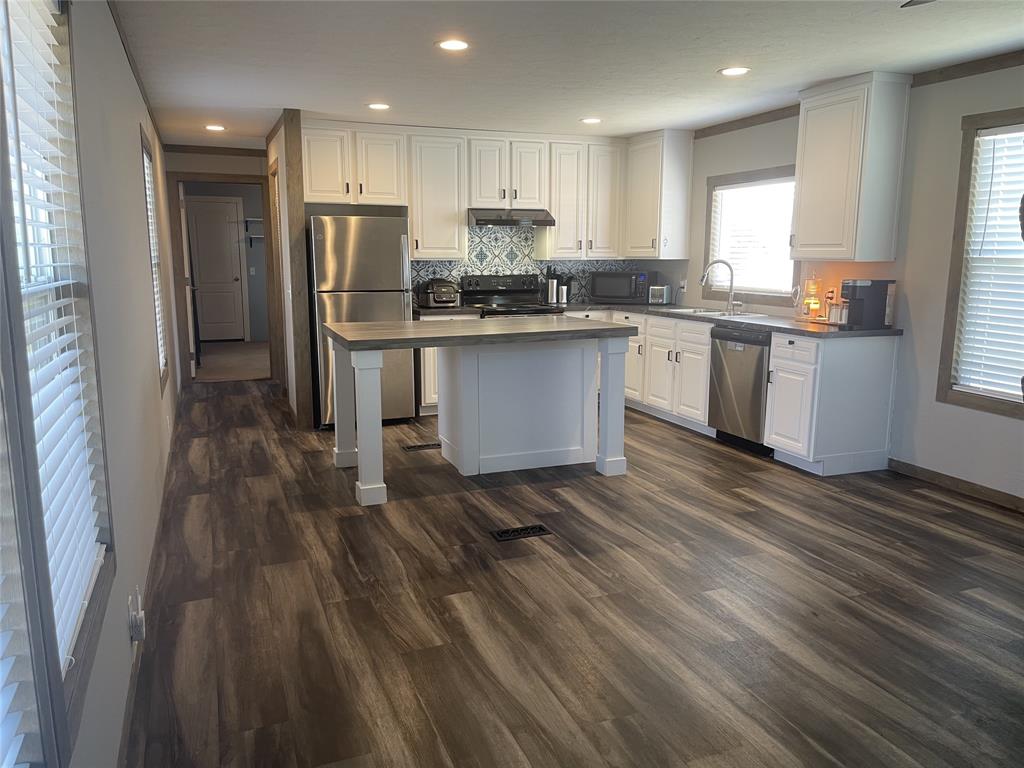 4937 Stuart Road Denton, TX 76207 - Photo 15 of 19 a kitchen with stainless steel appliances granite countertop a refrigerator a sink dishwasher a stove and white countertops with wooden floor
