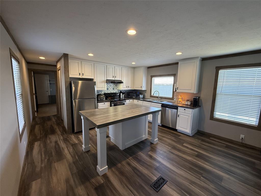 4937 Stuart Road Denton, TX 76207 - Photo 16 of 19 a kitchen with stainless steel appliances a refrigerator sink and wooden cabinets