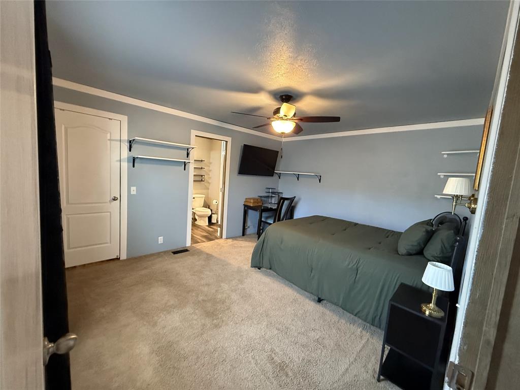 4937 Stuart Road Denton, TX 76207 - Photo 18 of 19 a bedroom with a bed and a chandelier