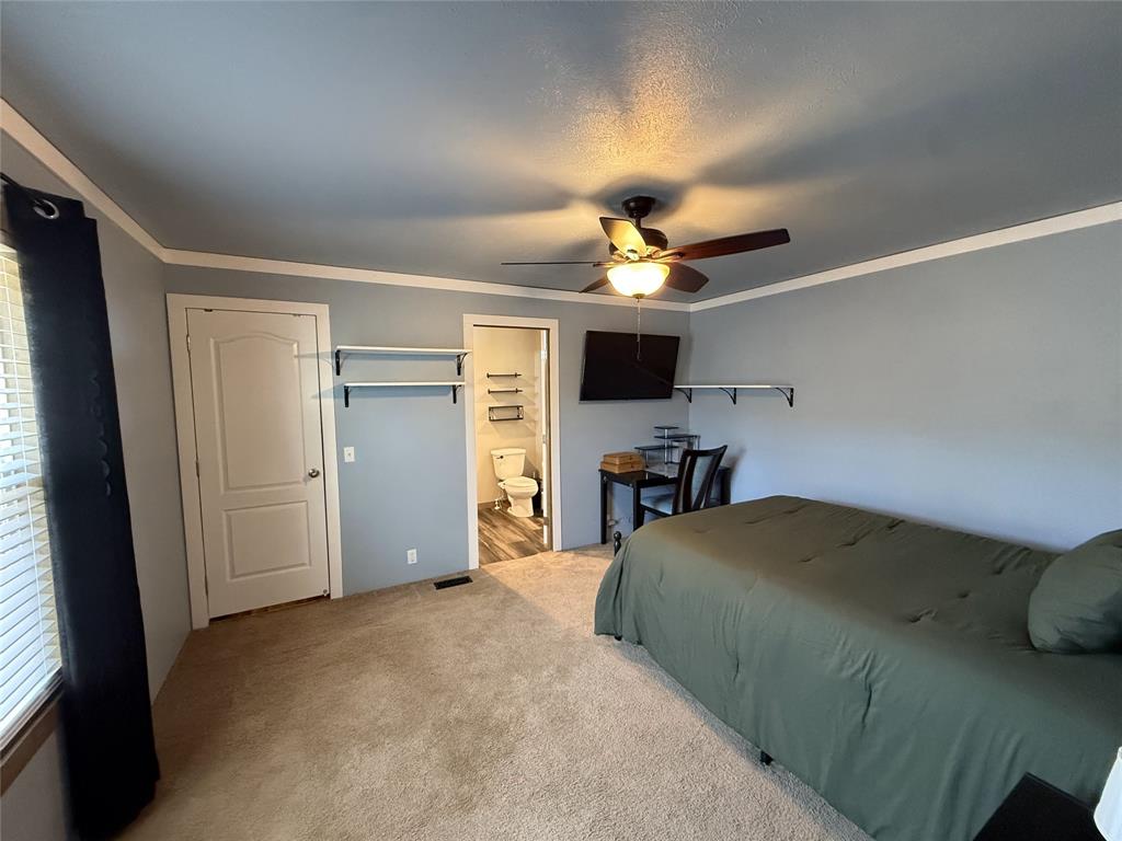 4937 Stuart Road Denton, TX 76207 - Photo 19 of 19 a bedroom with a bed and a chandelier