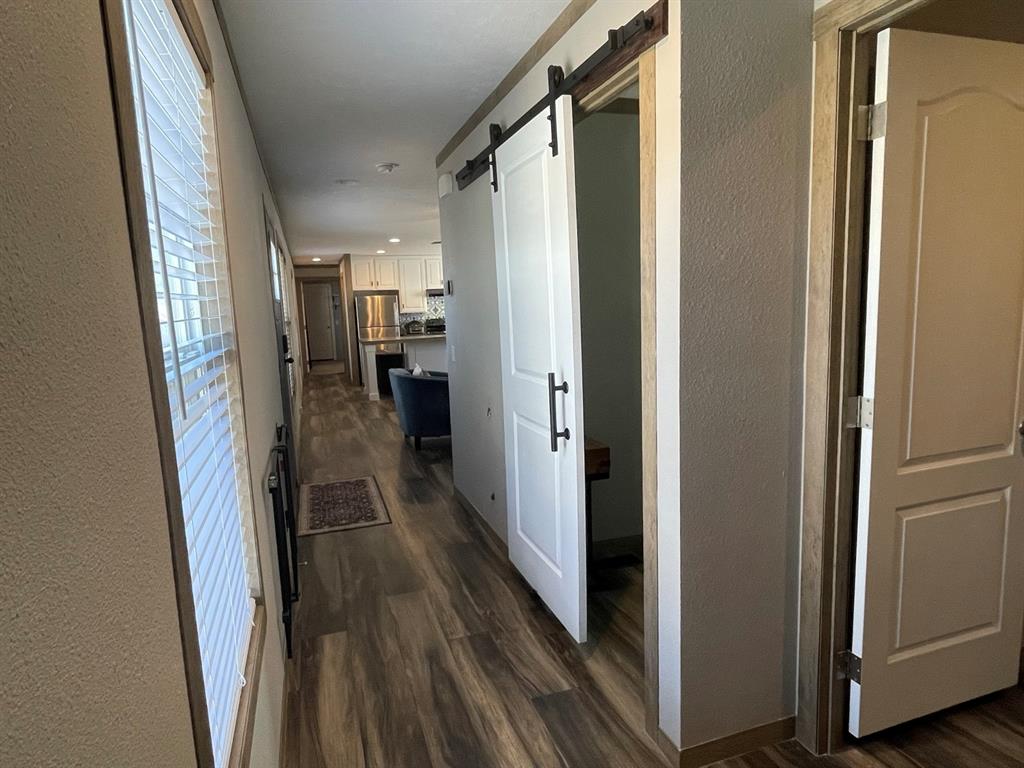 4937 Stuart Road Denton, TX 76207 - Photo 10 of 19 a view of a hallway with wooden floor and cabinets