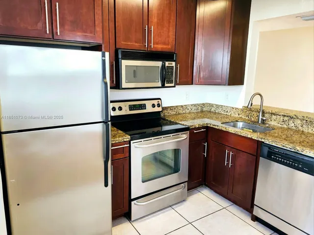 a kitchen with granite countertop cabinets stainless steel appliances and a counter space