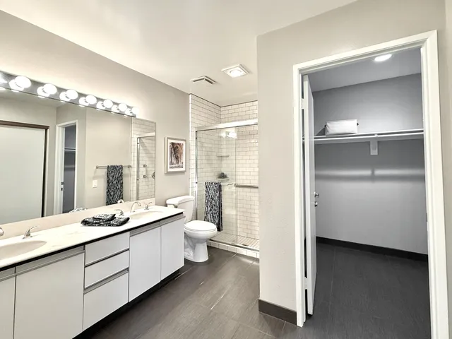a bathroom with a double vanity sink mirror and toilet