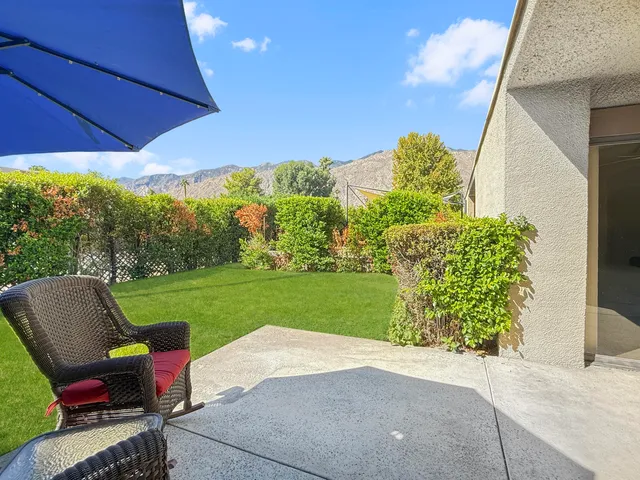 a view of a patio with a table and chairs under an umbrella